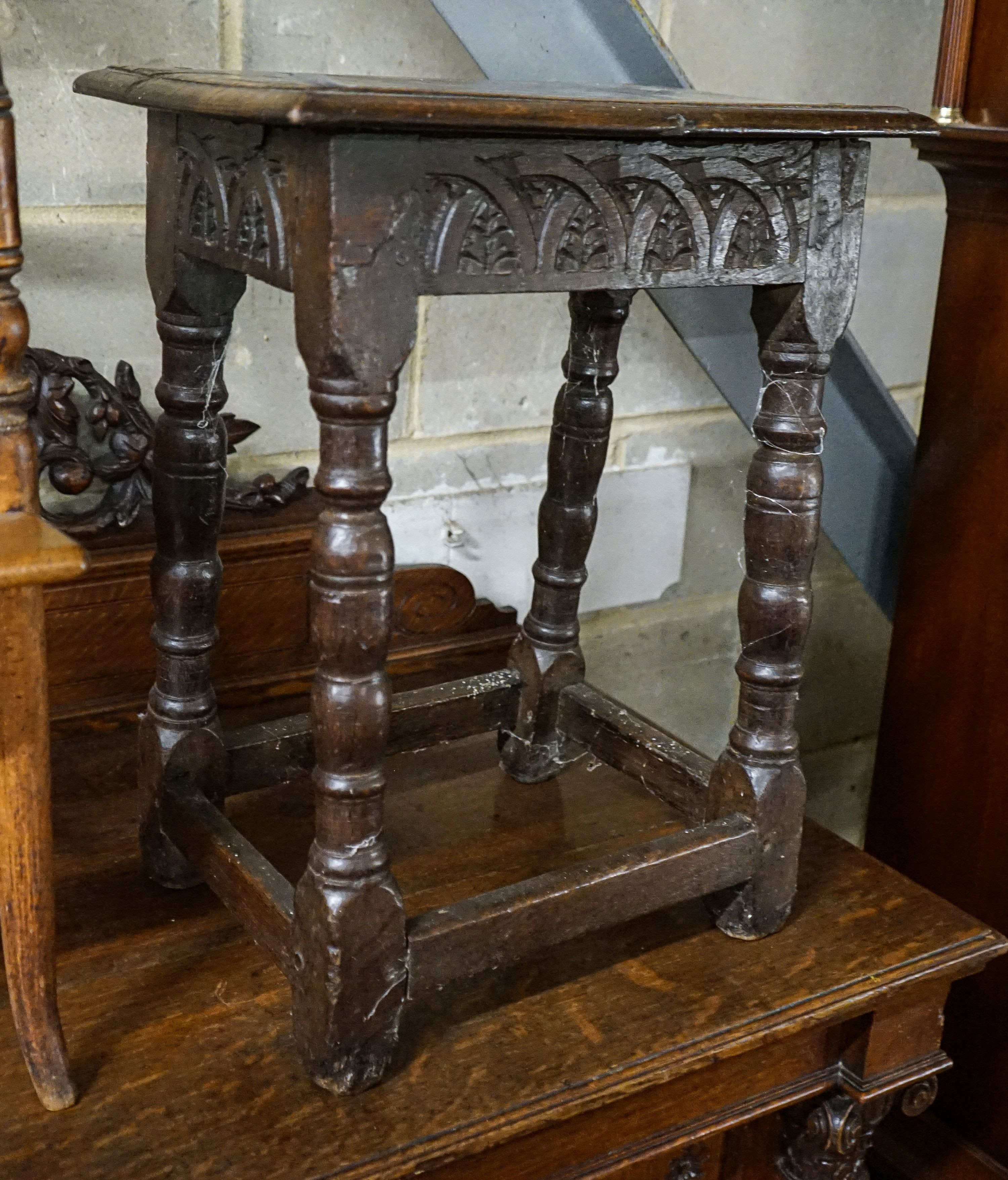 A 17th century style oak joint stool, with foliate carved frieze and turned legs, width 44cm, depth 28cm, height 56cm